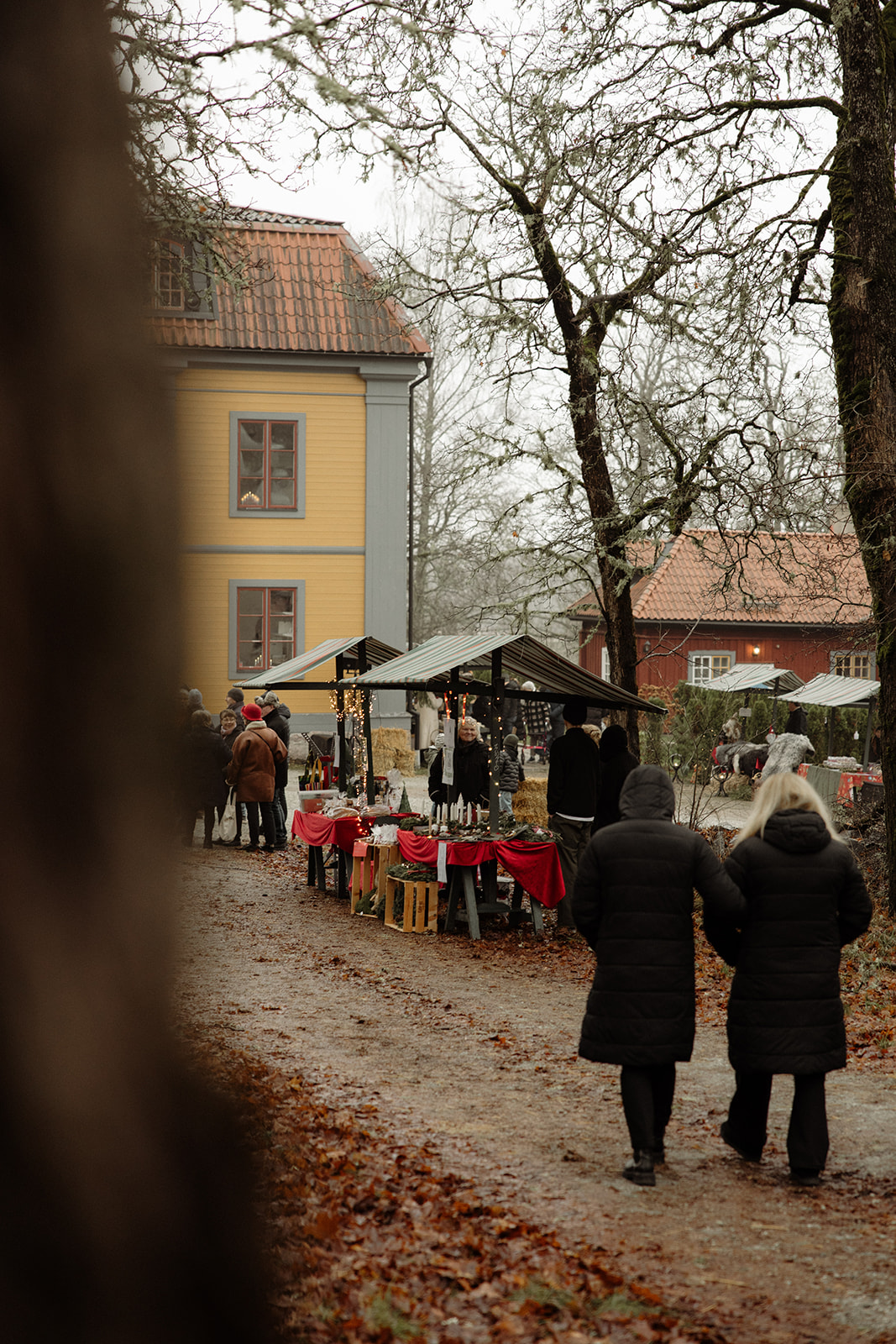 Besökare på marknaden med herrgården i bakgrunden